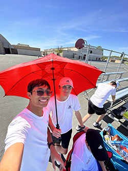 Preston and his friend Ryan holding a red umbrella at Los Banos high school